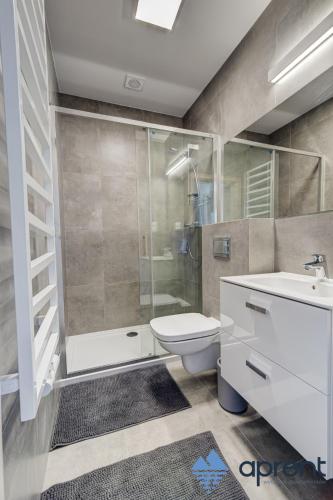 a bathroom with a shower and a toilet and a sink at Dom FANØ Baltic 2 - Aprent in Pobierowo