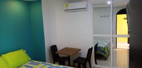 a room with a bed and a table and a mirror at Hotel Español Neiva in Neiva