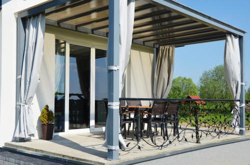 a screened in porch with a table and chairs at Domki na Wzgórzu - Rospuda in Filipów