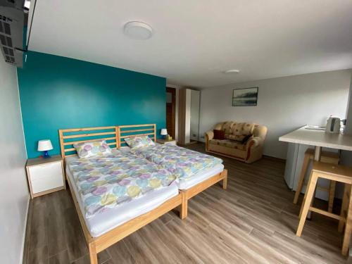 1 dormitorio con cama y pared azul en Agroturystyka "U Klaudii", en Mikołajki