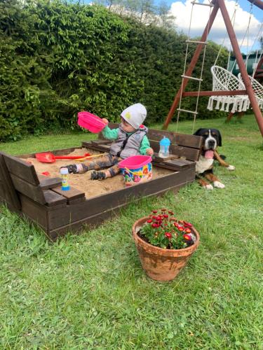 a young child playing in a sandbox in a sandbox at Agro na Wapniarni in Białla