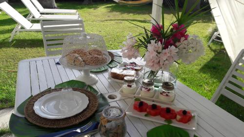a picnic table with a plate of food and flowers at La Casa di Nina in La Maddalena