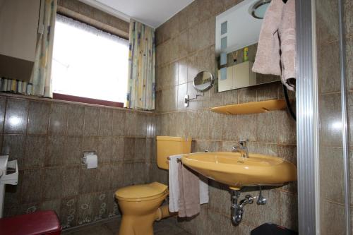 a bathroom with a yellow toilet and a sink at Ferienhaus Marienweg in Hallenberg