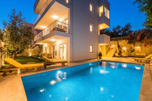 a swimming pool in front of a house at Garden Court Apartments in Kalkan