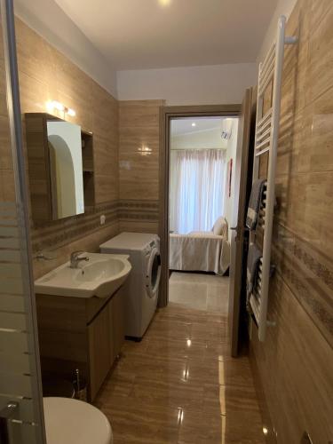 a bathroom with a sink and a washing machine at Villa Valmas Private Escape in Skiathos