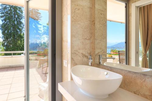 uma casa de banho com uma banheira, um lavatório e uma janela em Aurum em Baveno
