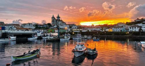 um grupo de barcos na água ao pôr do sol em Marina de São Mateus em Angra do Heroísmo