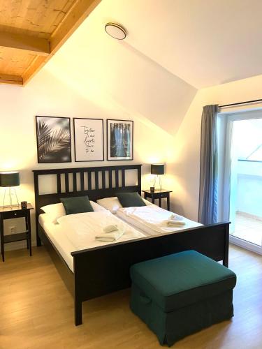 a bedroom with a large bed with a green ottoman at Apartmán Klára in Terchová