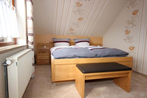 a small bedroom with a bed and a stool at Ferienhaus Marienweg in Hallenberg