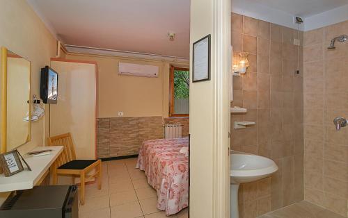 a bathroom with a bed and a sink and a toilet at Hotel Storyville - svago e convenzioni aziendali in Cinquale