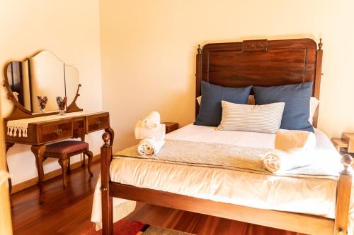 a bedroom with a bed with a mirror and a dresser at Recanto do Pinheiro in Arga de Baixo