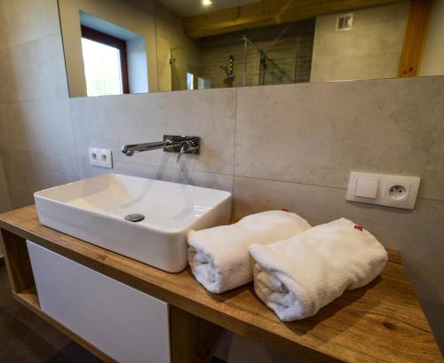 a bathroom with a sink and towels on a counter at Białowieska Chata in Białowieża