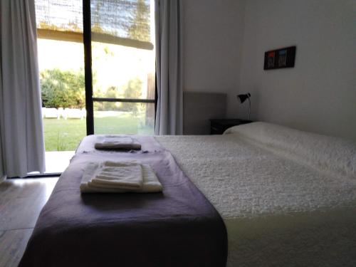 1 dormitorio con 1 cama con 2 toallas en Mini casa en Chacras de Coria