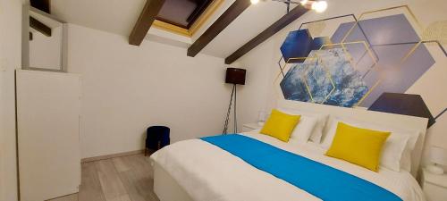 una camera da letto con un letto con cuscini gialli e blu di Guest House Galeb2 a Rab
