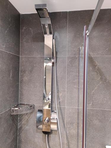 a shower in a bathroom with a shower head at Mare Monte Luxury Apartments 3 in Nea Skioni