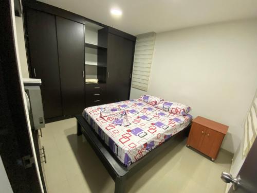 - une petite chambre avec un lit et une armoire dans l'établissement Apartamento Villavicencio Elegante, à Villavicencio