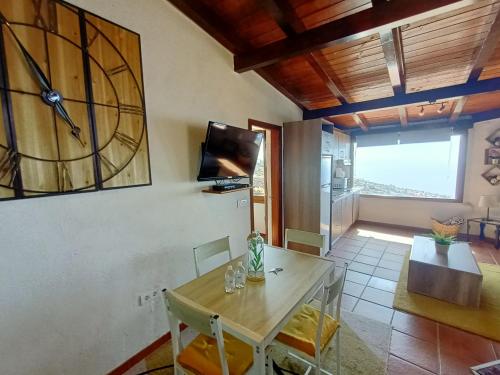 sala de estar con mesa y reloj en la pared en Apartamento Maudes de StarApsTenerife, en Sauzal