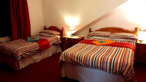 2 camas en una habitación de hotel con en Broomlea Guest House en Dyce