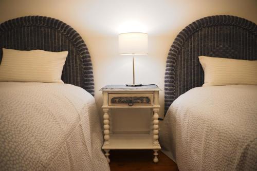 a bedroom with two beds and a table with a lamp at 4 Cantos in Faro