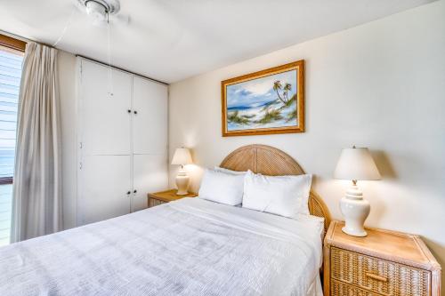 a bedroom with a bed and two lamps and a window at Nohonani 306 in Kahana