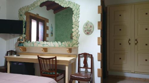 una camera da letto con specchio e scrivania con 2 sedie di Agriturismo Duca di San Martino a Partanna
