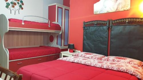 PartannaにあるAgriturismo Duca di San Martinoの赤い壁のベッドルーム1室(二段ベッド2組付)