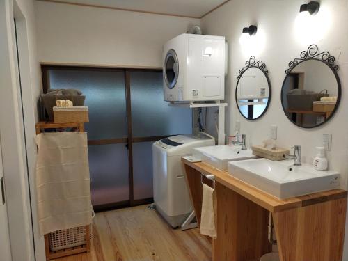 a bathroom with two sinks and a washer and dryer at 奈良五條の宿 彩 irodori in Gojō