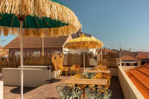 a patio with tables and chairs and umbrellas at Behappy Lodge & Brunch in Esmoriz