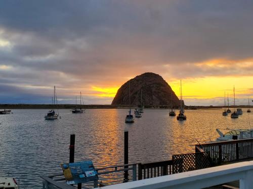 a group of boats in a body of water with a mountain at Gray's Inn & Gallery in Morro Bay