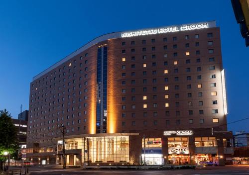 a large building with a sign on top of it at Nishitetsu Hotel Croom Hakata in Fukuoka