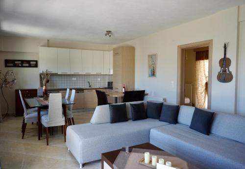 a living room with a blue couch and a kitchen at Casa Ideale in Limenaria