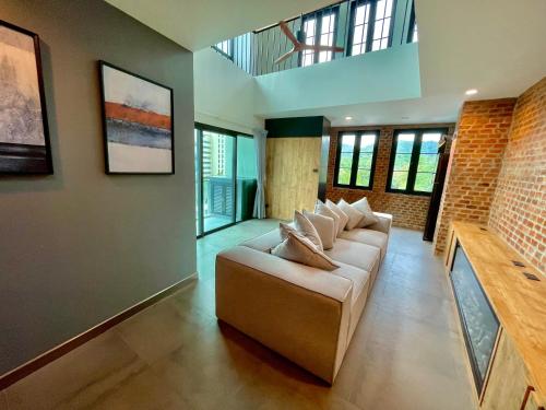 un soggiorno con divano e alcune finestre di Room Actually Service Apartment a Karon Beach
