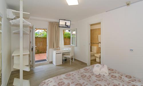 a bedroom with a bed and a desk and a room at Hotel Storyville - svago e convenzioni aziendali in Cinquale