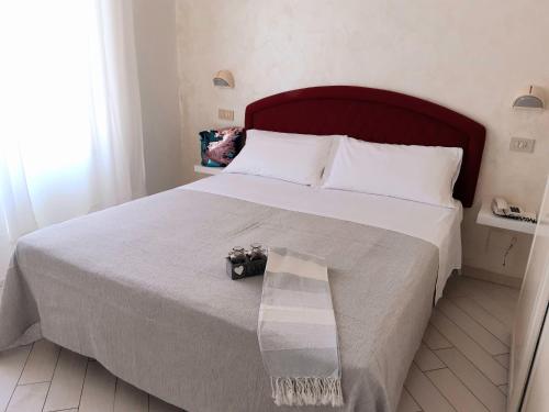 a bedroom with a large bed with a bench on it at Hotel Raul in Riccione