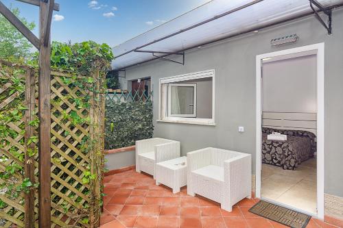 a patio with two white chairs and a door at Hotel Storyville - svago e convenzioni aziendali in Cinquale