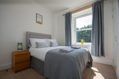 Schlafzimmer mit einem Bett und einem Fenster in der Unterkunft Dwellcome Home Ltd 1 Bed Aberdeen Apartment - see our site for assurance in Aberdeen