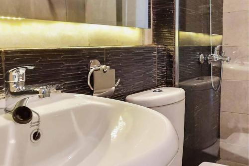 a bathroom with a white sink and a toilet at RedDoorz near RS Royal Prima Medan 2 in Medan