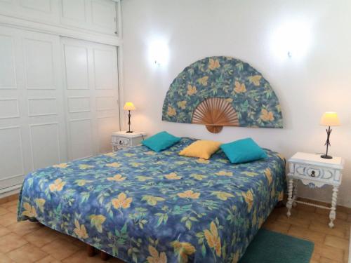 a bedroom with a bed with a blue comforter at Ocean facing at Senhora da Rocha in Porches