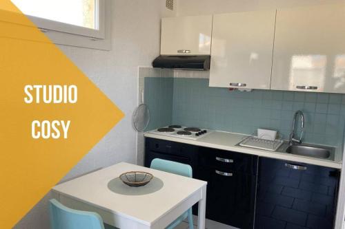 une cuisine avec une table, un évier et une cuisinière dans l'établissement Le BARCA Playa - Climatisé - Terrasse et Parking privé, au Barcarès