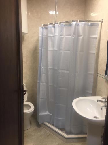 a bathroom with a shower and a toilet and a sink at Квартира у моря Колхида in Makhinjauri