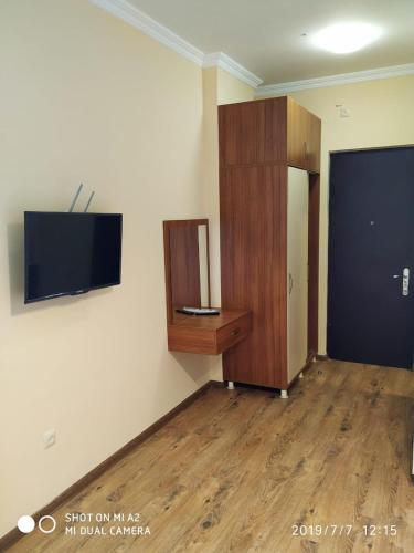 a room with a cabinet and a television on a wall at Квартира у моря Колхида in Makhinjauri