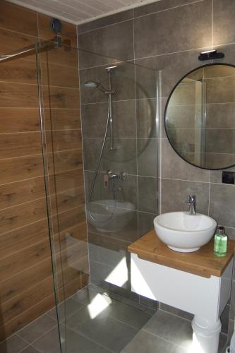 a bathroom with a sink and a glass shower at Aurora - Domki całoroczne nad morzem w Dziwnówku in Dziwnówek