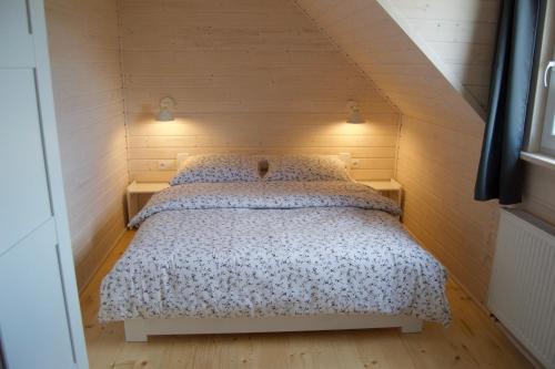 a bedroom with a bed in a small room at Blockhaus Aurora in Dziwnówek