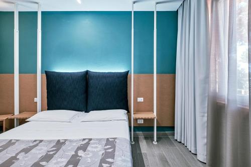 a bed in a room with a blue wall at Hotel Storyville - svago e convenzioni aziendali in Cinquale