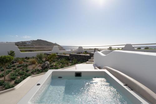 a hot tub on the balcony of a house at La Ponta Villas & Suites in Akrotiri