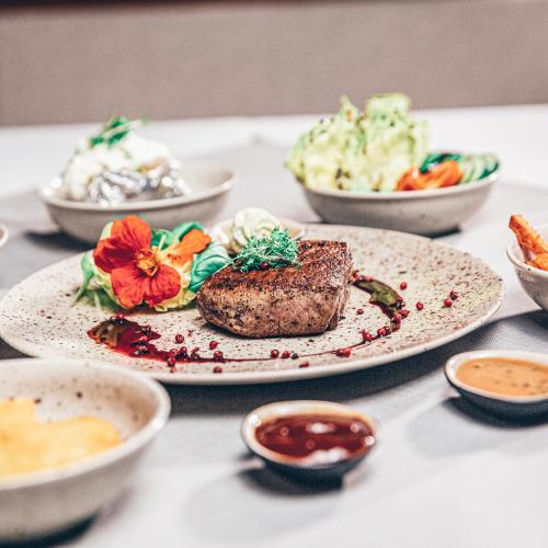a table with plates of food and bowls of food at Hotel Bayrischer Hof in Wels