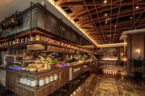 a restaurant with a counter with food on it at Jinling Grand Hotel in Chongqing