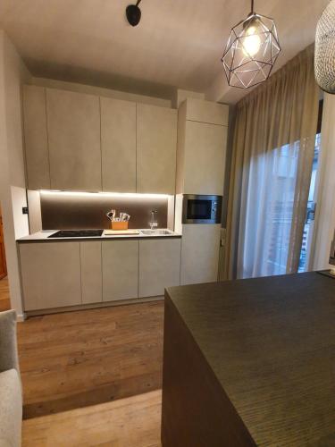 a kitchen with white cabinets and a black counter top at Brosi 11 in Forlì