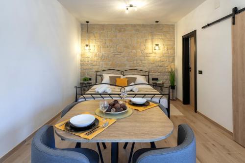 a dining room with a table and blue chairs at TEONA Luxury Studio Apartment with jacuzzi and terrace sea view in Sali