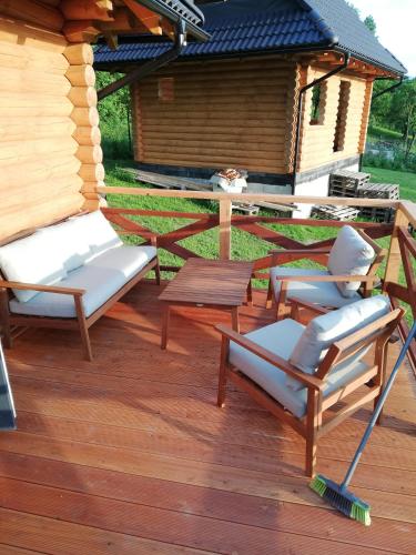 a wooden deck with chairs and a table at Drevenica Magdaléna in Trstené